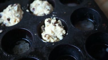 Bir kadın eski fırın tepsisine muffin meyilli kaşık