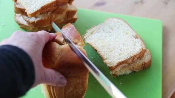 女性は ブリオッシュのパンをスライスするために鋸歯状のナイフを使用しています — ストック動画