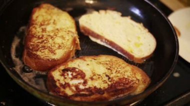 Bir metal spatula kullanarak, bir kadın bitmiş fransız tost kaldırır