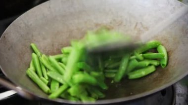 Bir metal spatula kullanarak bir wok taze sebze pişirme