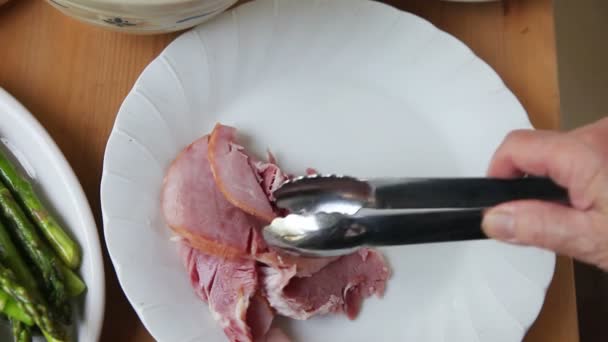 Una Mujer Coloca Rebanadas Jamón Espárragos Ensalada Papas Plato Blanco — Vídeo de stock