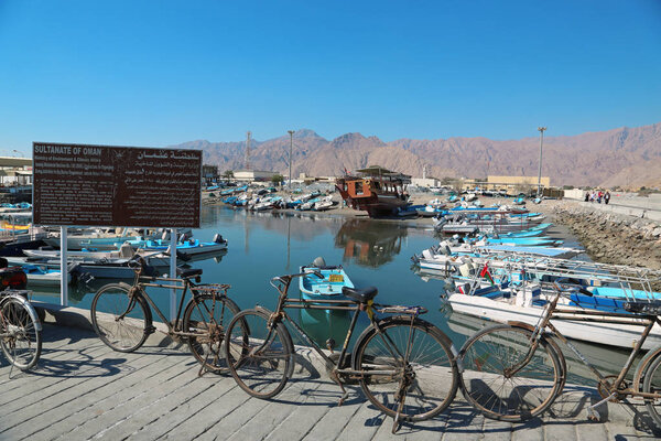OMAN, MUSANDAM PENINSULA, DIBBA, FEBRUARY 2, 2016: Bicycles and boats in Dibba Al-Baya harbour in Oman - arab country in southeastern coast of the Arabian Peninsula. Musandam - governorate of Oman