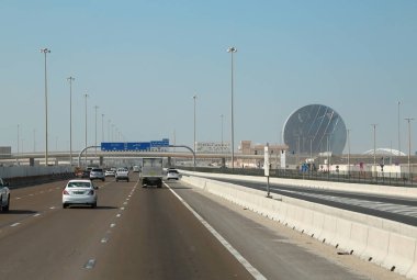 BAE, Abu Dhabi, 4 Şubat 2016: Karayolu trafik Aldar Abu Dabi - Birleşik Arap Emirlikleri, başkenti ve ikinci en kalabalık Dubai sonra bina Headquarters yakınındaki