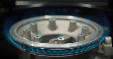 Mutfak gaz sobasından çıkan mavi gaz alevleri. Yanan ateşle gaz ocağı