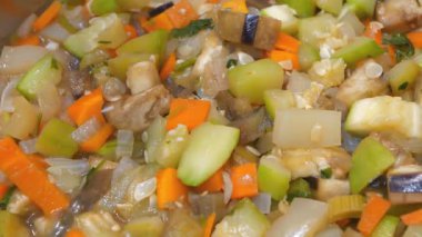 Gaz sobasında sebze güveci pişirilir. Ragout metal tavada pişiyor. Sebze yahnisi: patlıcan, kabak, salatalık, havuç, sarı biber, beyaz ve yeşil soğan, dereotu, maydanoz, tuz, baharat