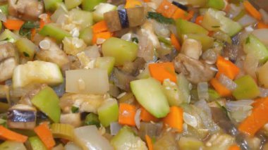 Gaz sobasında sebze güveci pişirilir. Ragout metal tavada pişiyor. Sebze yahnisi: patlıcan, kabak, salatalık, havuç, sarı biber, beyaz ve yeşil soğan, dereotu, maydanoz, tuz, baharat