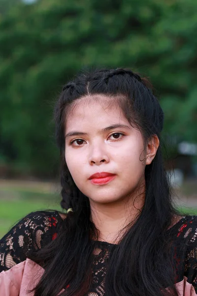 Genç güzel Genç filipina poz için fotoğraf makinesi ile doğa arka plan.