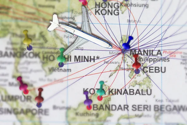 Trip to Manila with toy airplane and push pin  on map of The Philippines