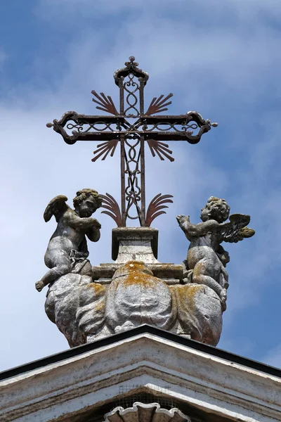 Angels kneeling under the cross, statue on facade of the Mantua Cathedral dedicated to Saint Peter, Mantua, Italy