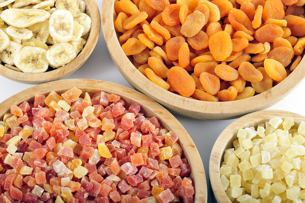 Dried and candied fruits in wooden bowls