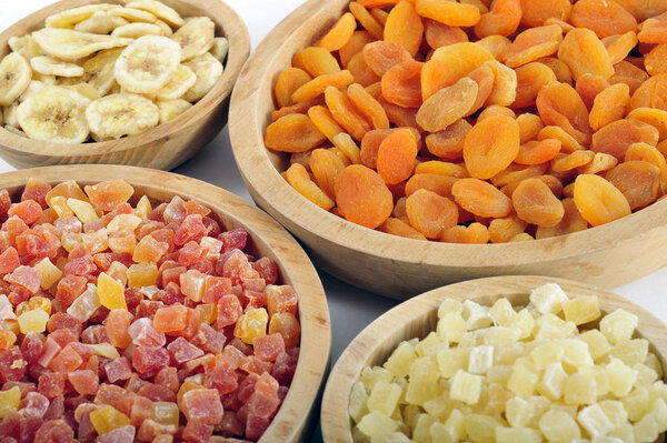 Dried and candied fruits in wooden bowls