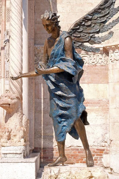 Angel statue outside of the Cathedral dedicated to the Blessed Virgin Mary under the designation Santa Maria Matricolare in Verona, Italy