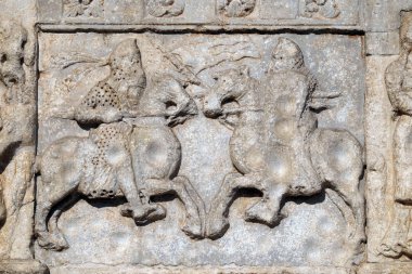 Knights fight horseback with lance and shield, medieval relief on the facade of Basilica of San Zeno in Verona, Italy clipart