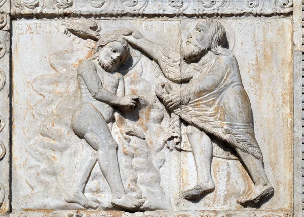 Baptism of the Christ, medieval relief on the facade of Basilica of San Zeno in Verona, Italy