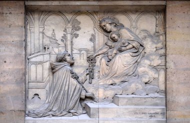 The Virgin giving the Rosary to Saint Dominic, by Theodore Charles Gruyere, relief on the portal of Saint Thomas Aquinas in Paris, France  clipart