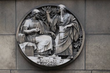 Asclepiade and Lucrece, Greek medicine in Rome. Stone relief at the building of the Faculte de Medicine Paris, France. clipart