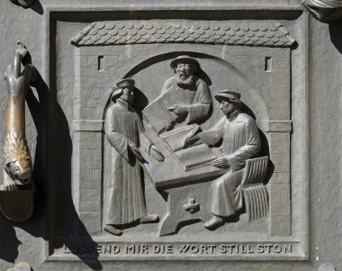 Work on the translation of the Bible, from left: Leo Jud, Theodor Bibiliander and Zwingli, relief on the door of the Grossmunster (