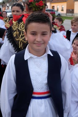 Halk kostümleri giymiş çocuk Stitar Şükran günü Ayin'de kiliseye gitmek, Hırvatistan
