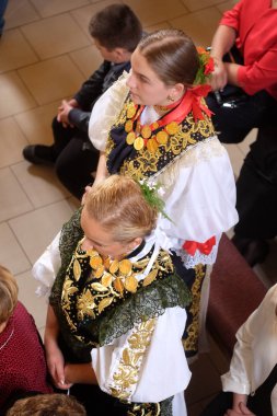 Stitar Şükran günü Ayin'de kilisede geleneksel bölgesel halk kostümleri giymiş kızlar, Hırvatistan