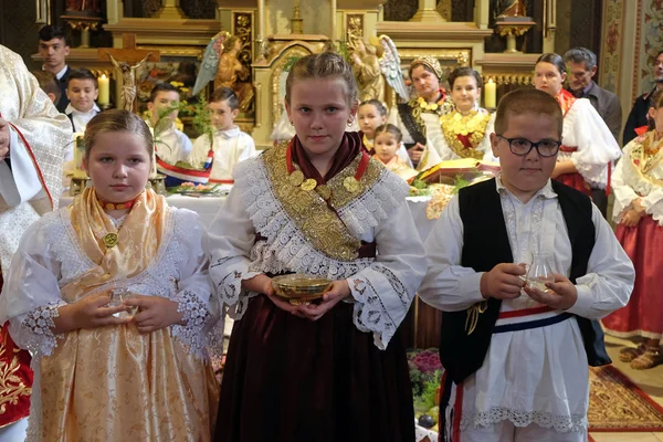 Stitar Şükran günü Ayin'de kilisede geleneksel bölgesel halk kostümleri giymiş çocuklar, Hırvatistan