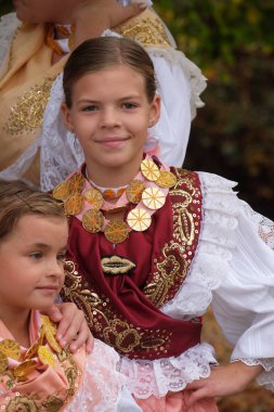 Girls dressed in folk costumes go to the church at the Mass on Thanksgiving day in Stitar, Croatia clipart