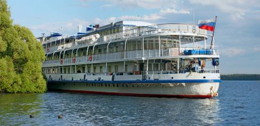 Ağaç güverte nehir kruvaziyer yolcu gemileri Volga Nehrinin yeşil kıyısında bir iskelede demirli vardır