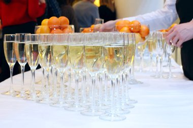 Bir bardak şampanya şenlikli masaya. Gözlük vererek garson