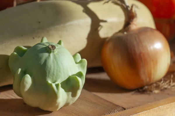 Kürbis und Zwiebel auf einem Holztisch. Stillleben auf dem Land — Stockfoto