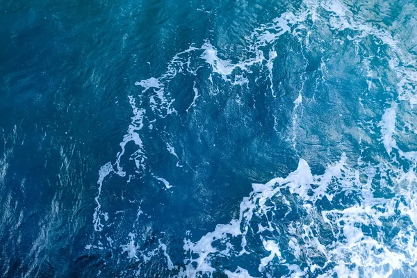 Superficie blu dell'acqua di mare con schiuma bianca. Vista dall'alto — Foto Stock