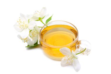 Beyaz arka planda yasemin çiçekli bir fincan yeşil çay.