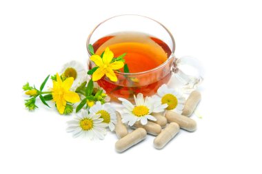 Şifalı bitki çayı ve şifalı bitkilerin kapsülleri beyaz arka planda. Bitkisel İlaç.