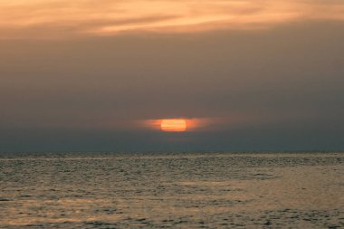 Mor ve turuncu gökyüzü ile denizde gün batımı