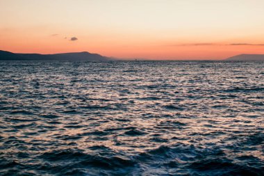 Mor ve turuncu gökyüzü ile denizde gün batımı