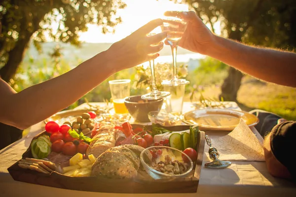 bir çift eski şehir parkında pike üzerinde beyaz şarap bardak ile tıklayarak