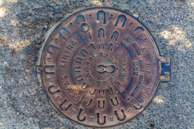 Beyaz binaları, terakotta çatısı, saksı bitkileri ve canlı çiçekleri olan sakin bir avlu berrak mavi gökyüzünün altında manzaralı bir okyanus manzarasına götürür.