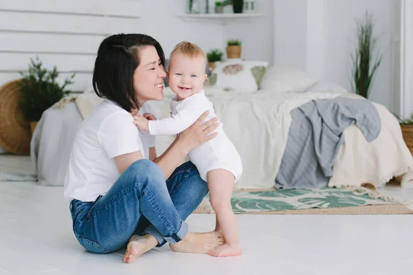 Home retrato de feliz jovem mãe asiática com seu pequeno bebê de raça mista. 1 ano de idade bebê . — Fotografia de Stock