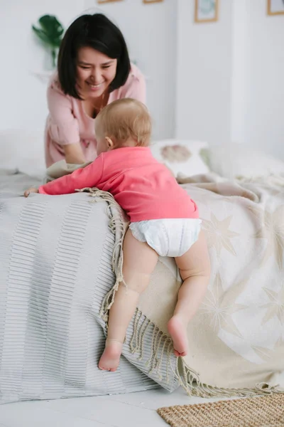 Anya tanítja kislányát, hogy biztonságosan menjen le a széle az ágy, hogy a padló. — Stock Fotó