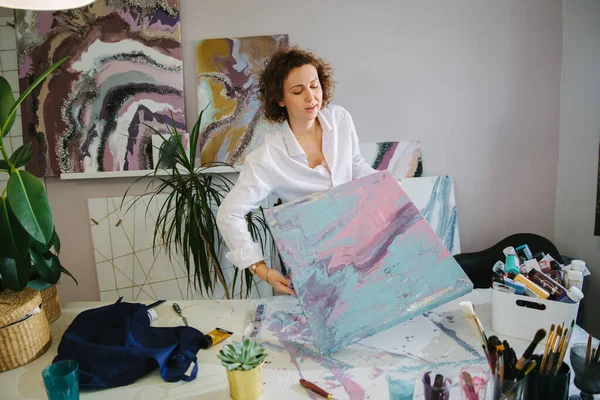 Portrait d'une jeune femme artiste en atelier, travaillant avec des peintures acryliques sur toile. Art des fluides — Photo