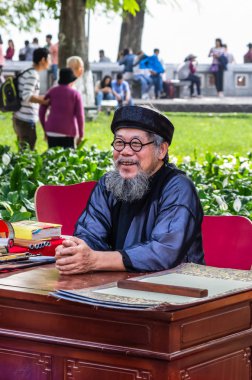 Hanoi, Vietnam - 14 Kasım: Ulusal elbiseli yaşlı Vietnamlı hiyeroglif Street eski kağıt üzerinde 13 Kasım 2016 Hanoi, Vietnam için de yazıyor