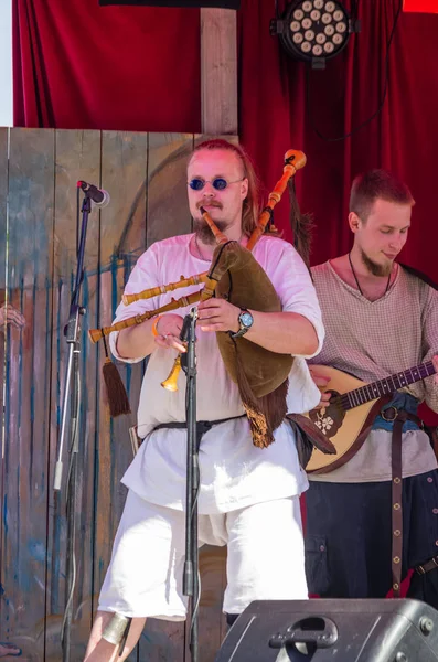 Portret van een mannelijke muzikant in traditionele middeleeuwse kleren spelen — Stockfoto