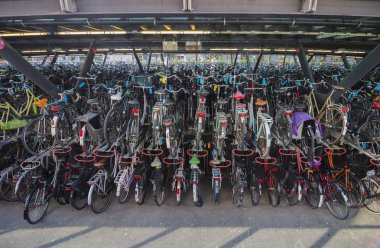 Leiden, Hollanda - 21 Nisan 2019. Köprünün altında Merkez tren istasyonu yakınında büyük iki katlı açık hava bisiklet park