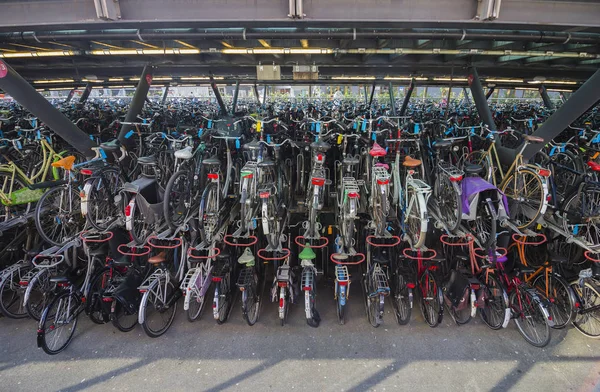 Leiden, Hollanda - 21 Nisan 2019. Köprünün altında Merkez tren istasyonu yakınında büyük iki katlı açık hava bisiklet park