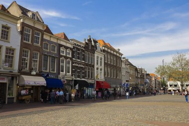 Gouda, Holland, Hollanda, Nisan 23, 2019. Gouda eski kentinde Pazar Meydanı, dükkanlar ve kafeler ile evlerin Hollandalı tarzı cepheleri bir sokak.