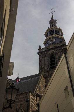 Gouda, Holland, Hollanda, Nisan 23, 2019. Gouda eski kentinde Pazar Meydanı, evler ve Sint-Janskerk kilise çan kulesi görünümü Hollandalı tarzı cepheler bir sokak (Hollanda 'da en yüksek)