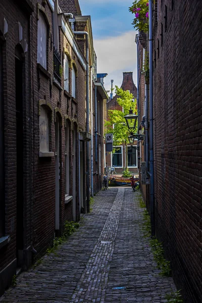 Leiden, Hollanda, Hollanda, 22 Mayıs 2019. Dar Sokak manzarası, geleneksel evler ve park edilmiş bisikletler.