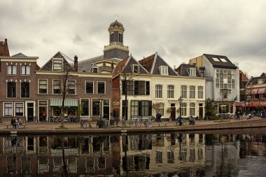 Leiden, Hollanda, Hollanda, 18 Nisan 2019, bisikletler her tarafa park edilmiş, köprüler, sokaklar, kanallar, kafeler, eski şehirde mavna, su daki tekneler, bisikletçi, şehirdeki insanlar