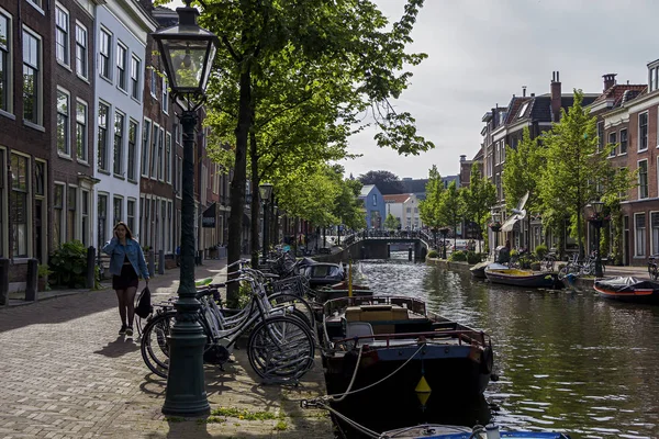 Leiden, Holland, Netherlands, Mayıs, 22, 2019, Bisiklet çevresinde park edilmiş, köprüler, sokaklar, kanallar, kafeler, eski şehirde mavna, su üzerinde tekneler, bisikletçi, şehirde insanlar