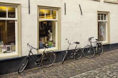 Leiden, Holland, Hollanda, Nisan 17, 2019. Venüs heykeli, geleneksel evler ve park edilmiş Bisikletler kopyası ile her zamanki sokak ve kitap mağazası pencereleri görünümü