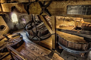 Leiden, Hollanda, Hollanda, 21 Nisan 2019. Molen De Valk müzesinin (Falcon yel değirmeni) geleneksel Hollanda un değirmeni dişlileri, değirmen taşları ve makinelerinin çatı katlarının (kaldırma, taş ve taşlama) iç mekanları.