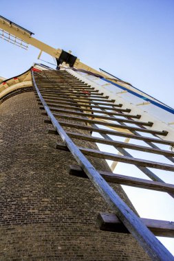 Leiden, Hollanda, Hollanda, 21 Nisan 2019.Molen De Valk müzesinin (Falcon yel değirmeni) geleneksel Hollanda un yel değirmeninin asma katının yelken aksının ve kapak tavan ının ve direksiyon simidinin yakından görünümü 